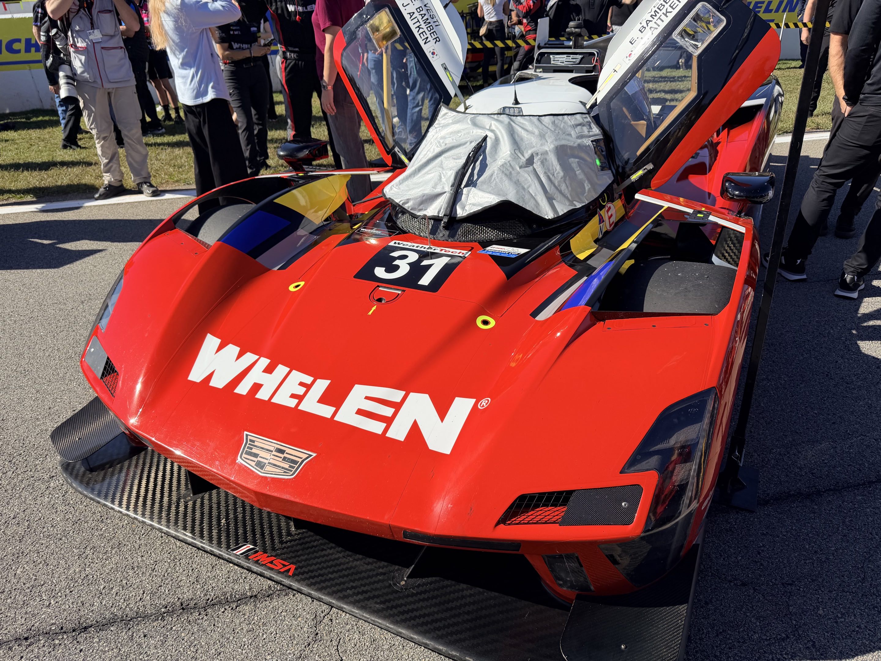 The #31 Cadillac V-Series.R LMDh parked on the grid at Road Atlanta with its doors up and cockpit covered